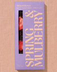 A rectangular chocolate bar packaged in lavender paper with beige text reading, "Mixed Berry"