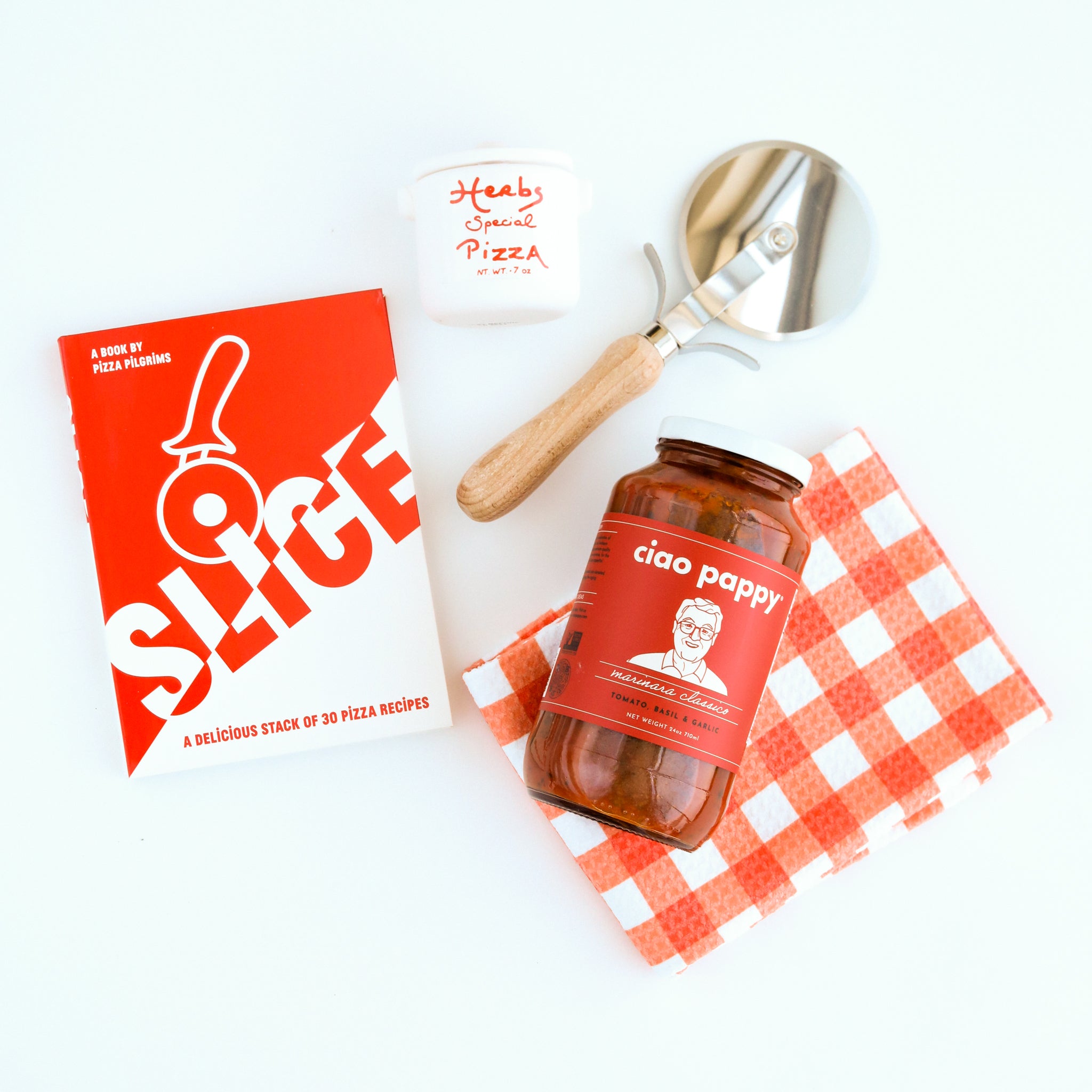  "Slice" Pizza book, wood pizza cutter, Ciao Pappy Marinara sauce, Pizza herbs jar and plaid red Geometry tea towel.