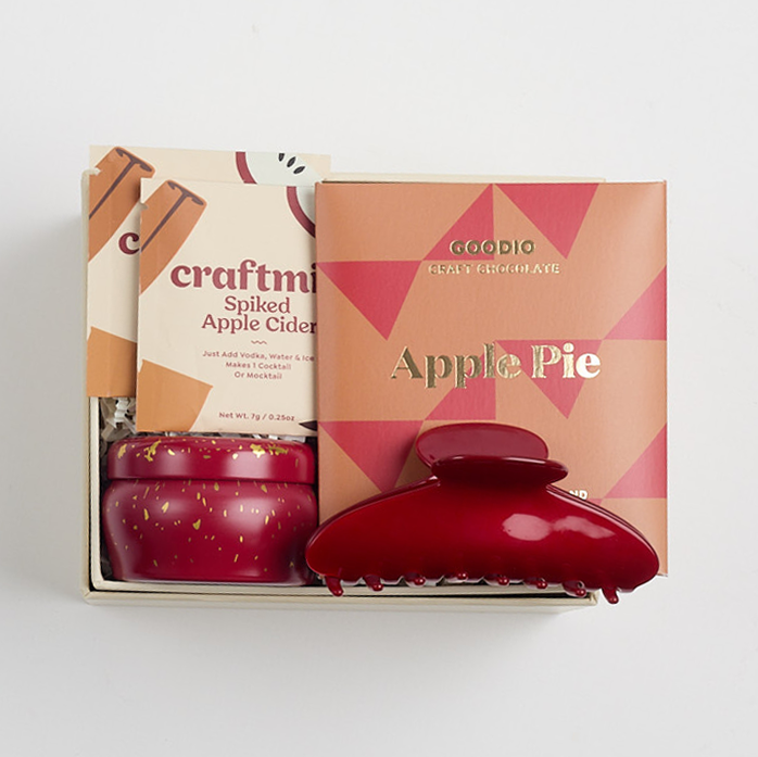 Apple pie chocolate bar, 2 spiked apple cider cocktail sachets, apple cider mini tin candle, and red claw clip packed in creme BOXFOX