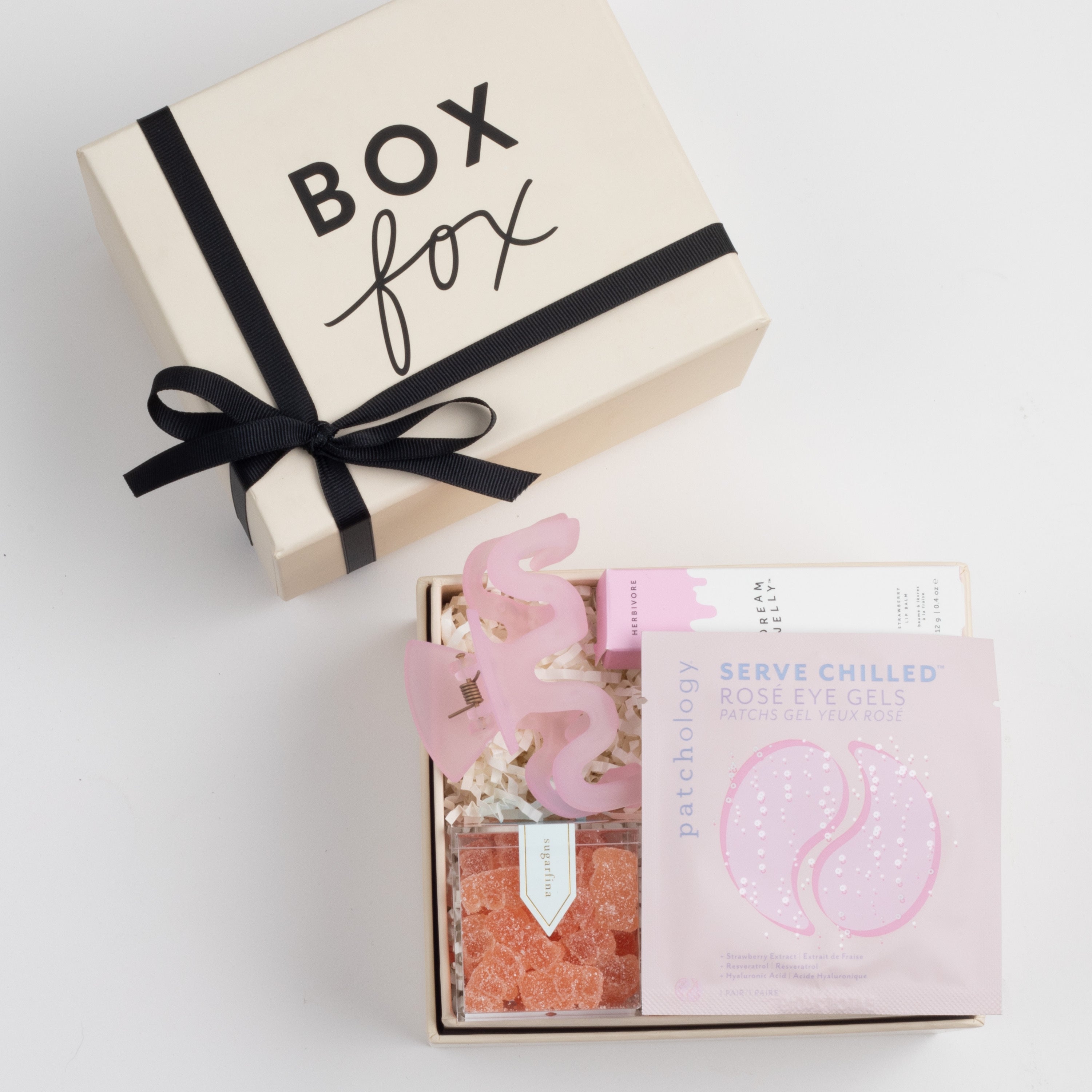 BOXFOX Bridesmaid Gift Box in Creme box with Sugarfina Sparkling Rosé Bears, Patchology Serve Chilled Rosé Eye Gels, Herbivore Dream Jelly Lip Balm, and NTBAB Pink Squiggle Hair Clip