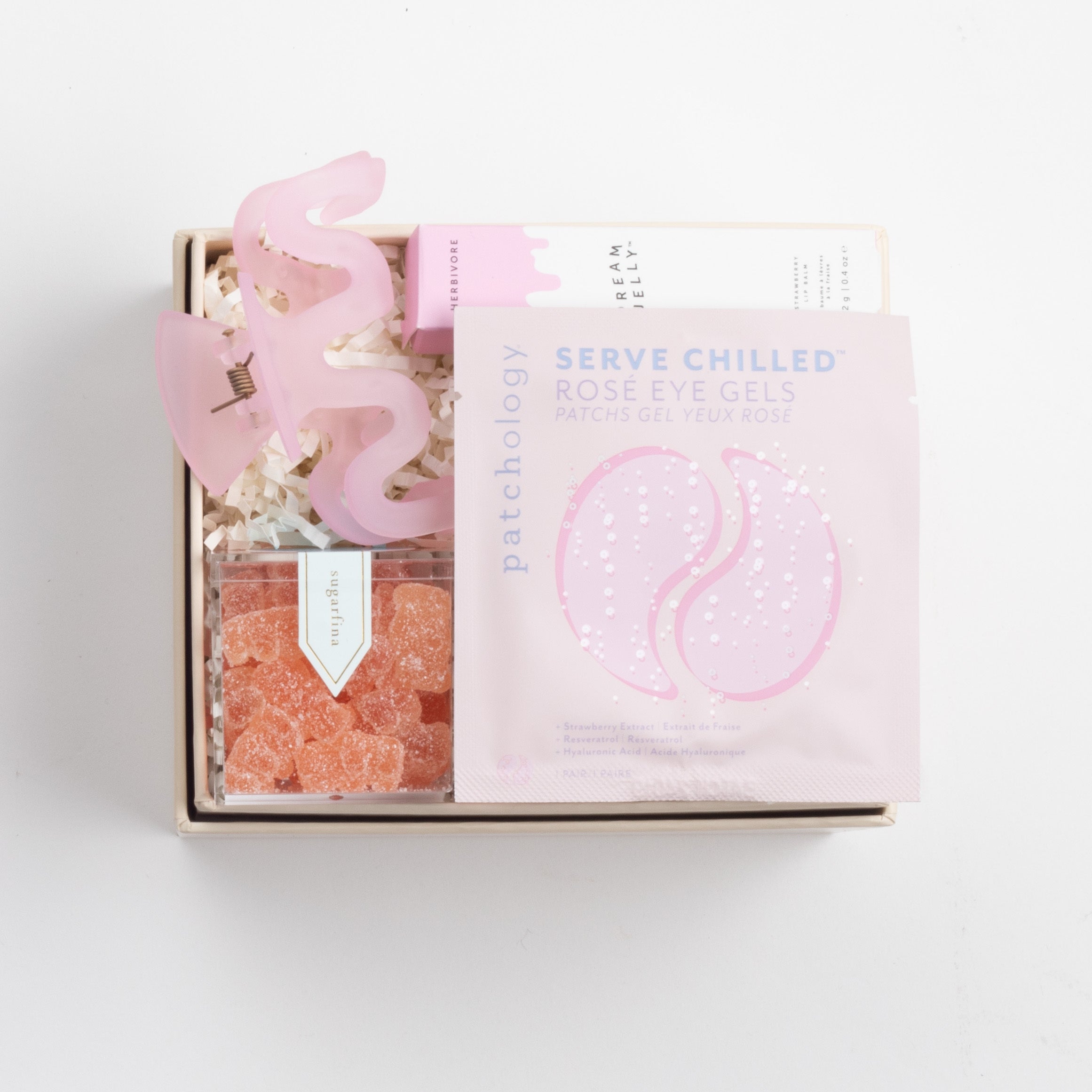 BOXFOX Bridesmaid Gift Box in Creme box with Sugarfina Sparkling Rosé Bears, Patchology Serve Chilled Rosé Eye Gels, Herbivore Dream Jelly Lip Balm, and NTBAB Pink Squiggle Hair Clip