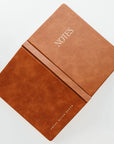 open brown leather journal that says 'NOTES' on it in gold