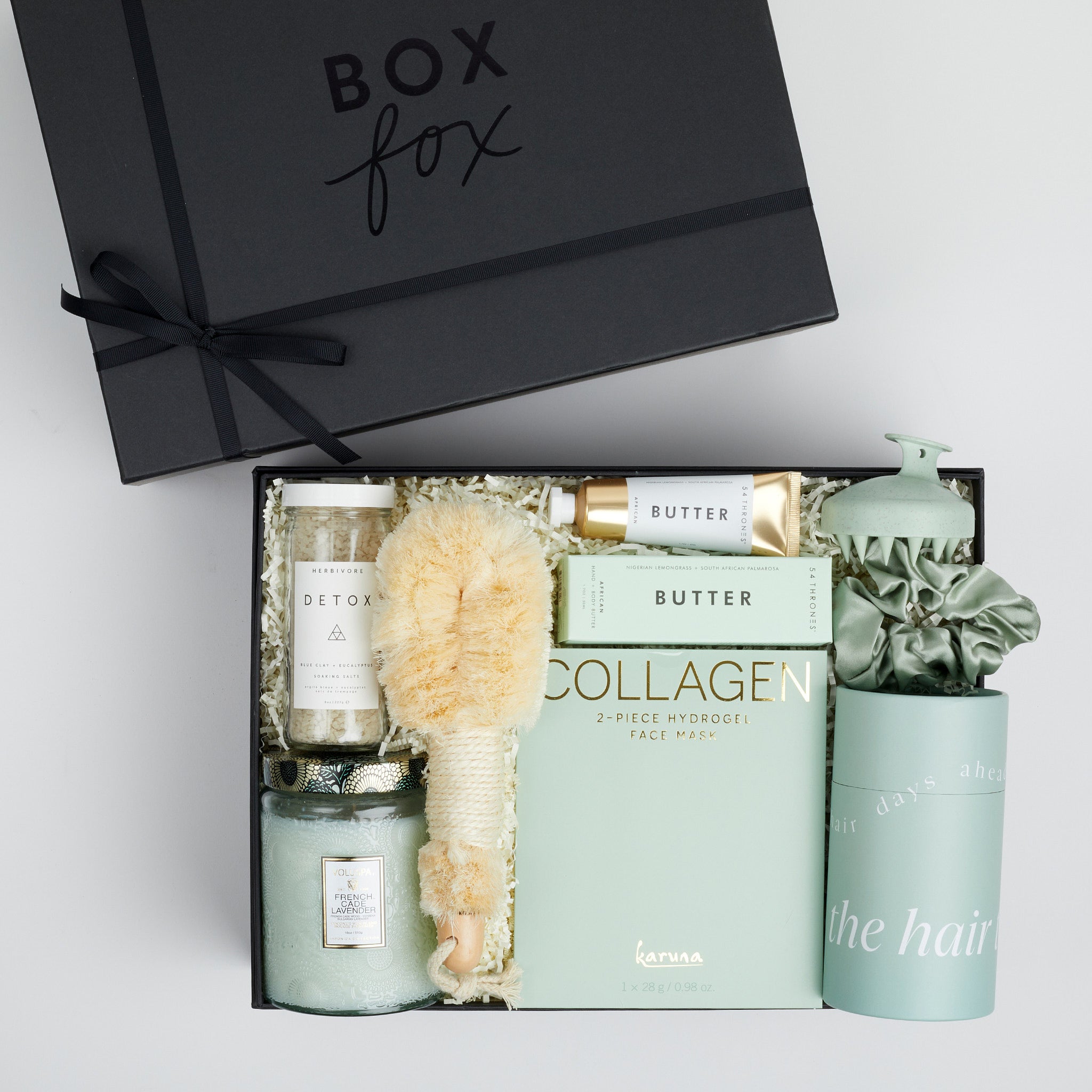The GREEN GODDESS gift box in black, including DETOX bath salts, large candle, dry brush, collagen face mask, hand cream, scalp scrubber, silk scrunchie and hair towel.