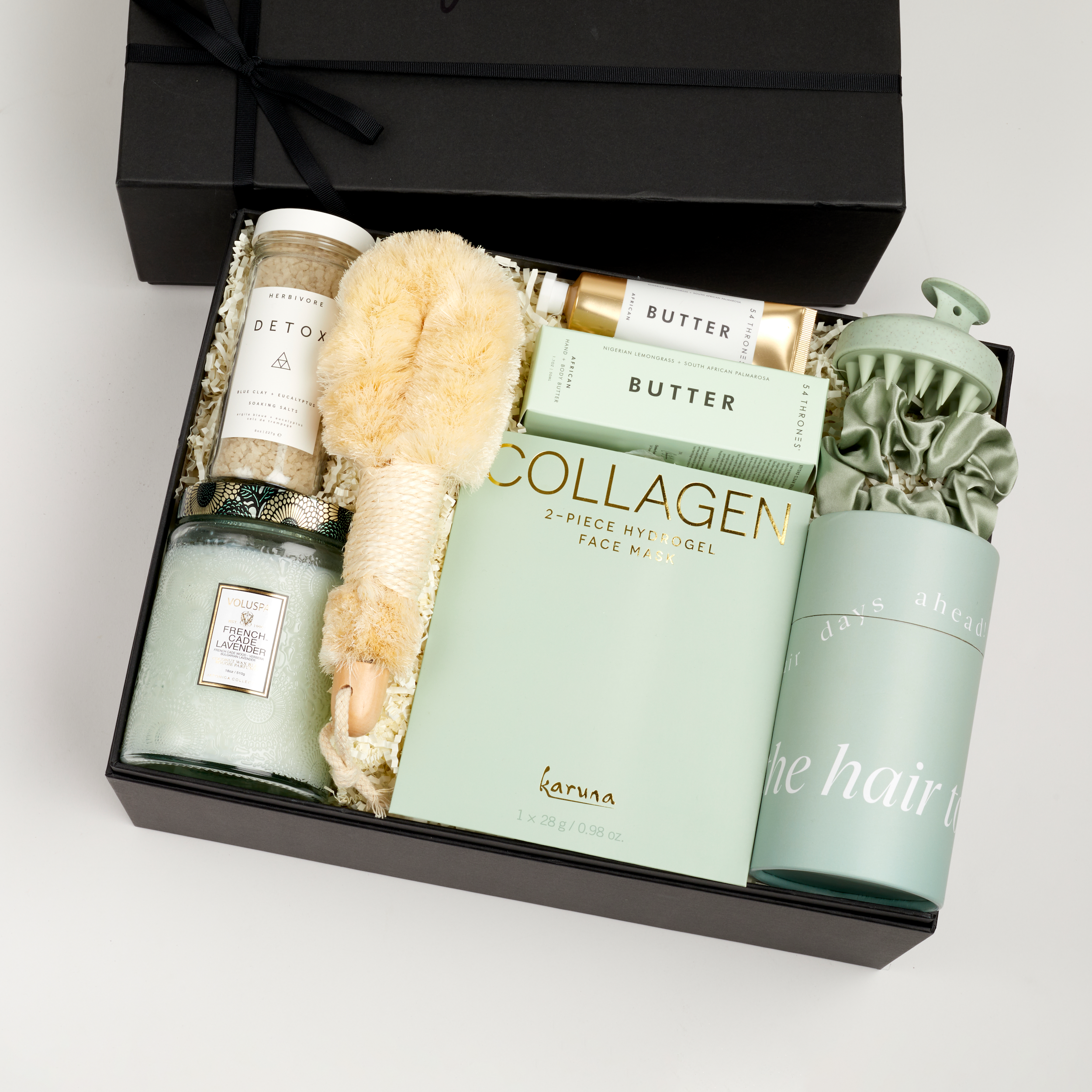 The GREEN GODDESS gift box in black, including DETOX bath salts, large candle, dry brush, collagen face mask, hand cream, scalp scrubber, silk scrunchie and hair towel.