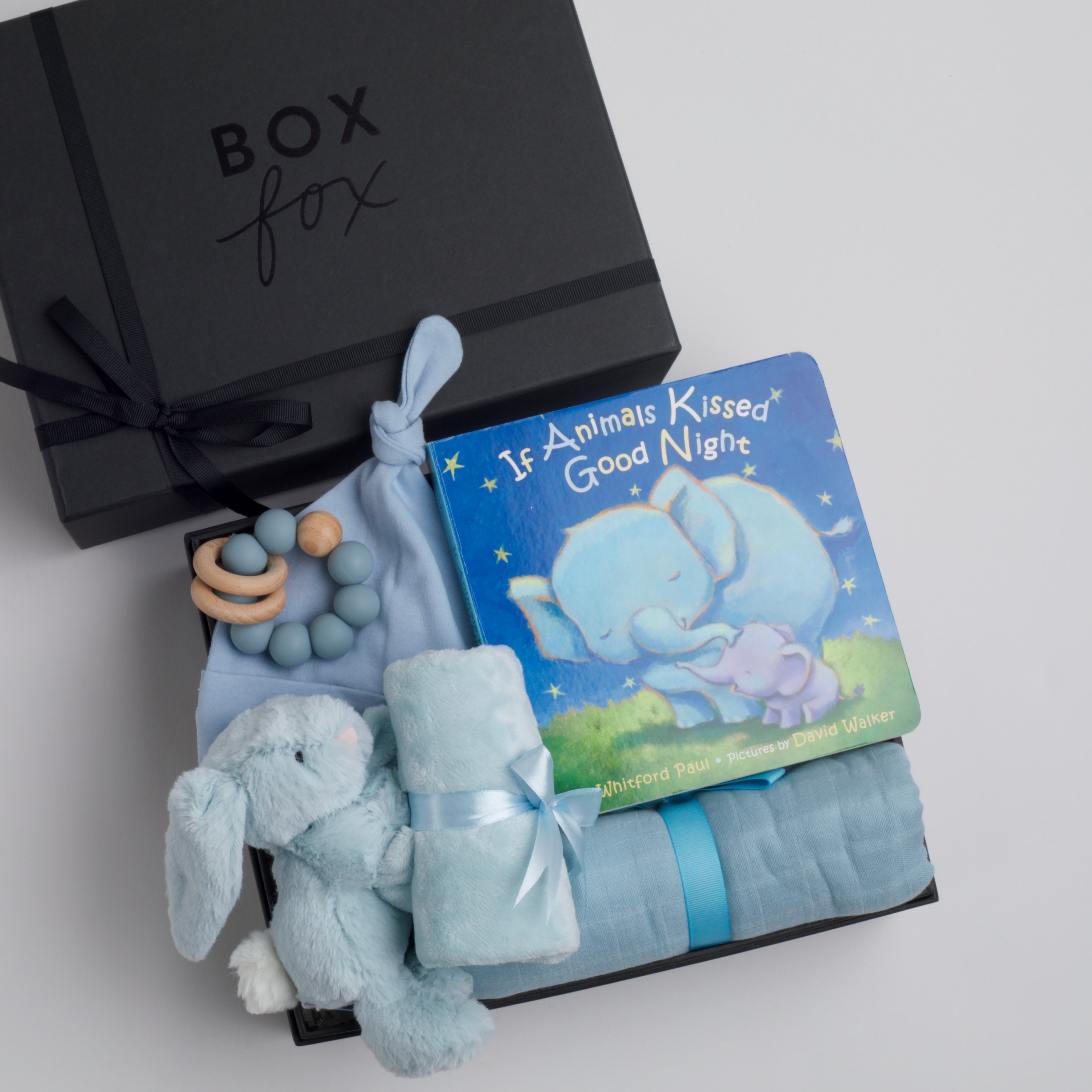 BOXFOX New Baby Boy Box including a swaddle, bunny soother, teether, hat, and book.