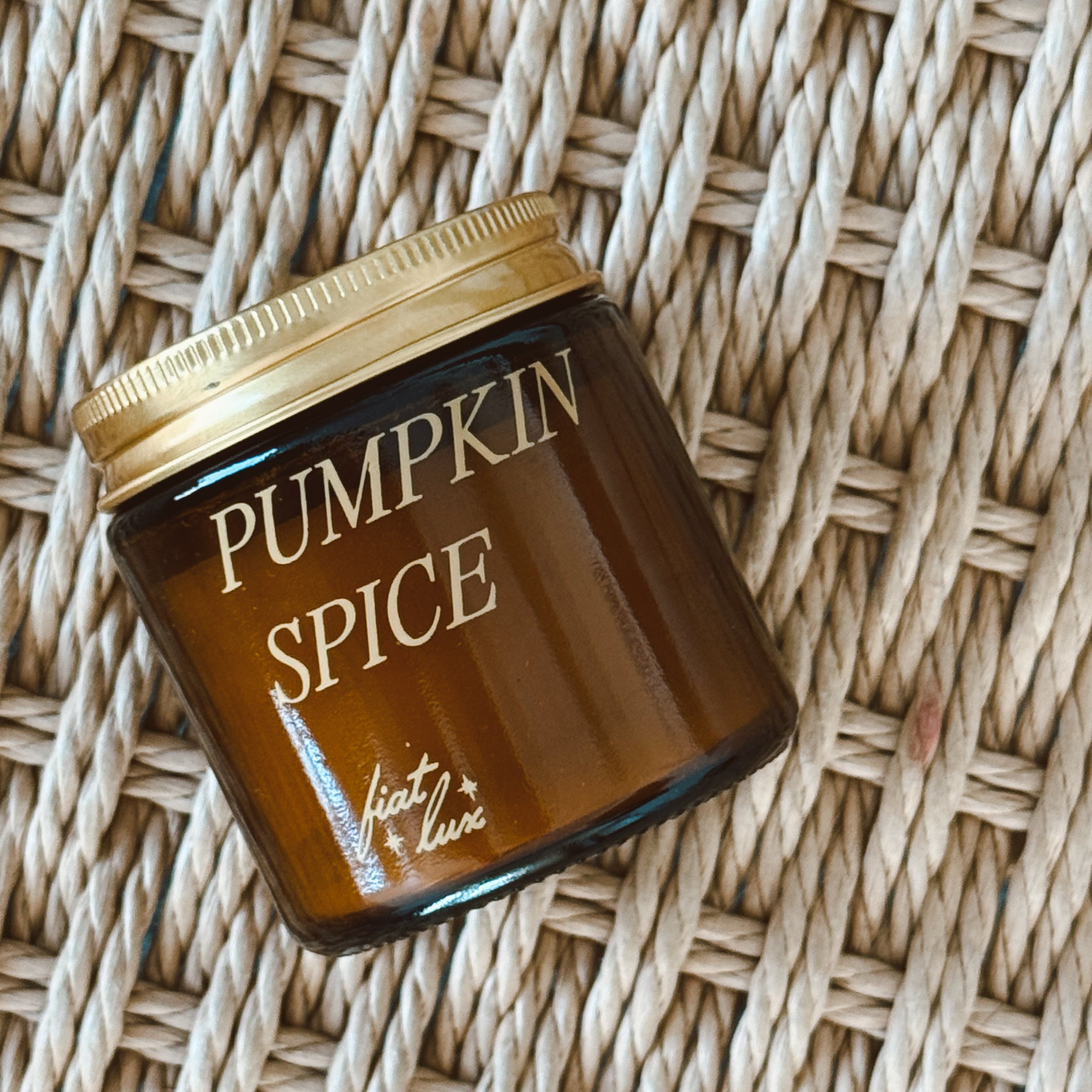 mini amber candle jar with 'PUMPKIN SPICE' printed on it