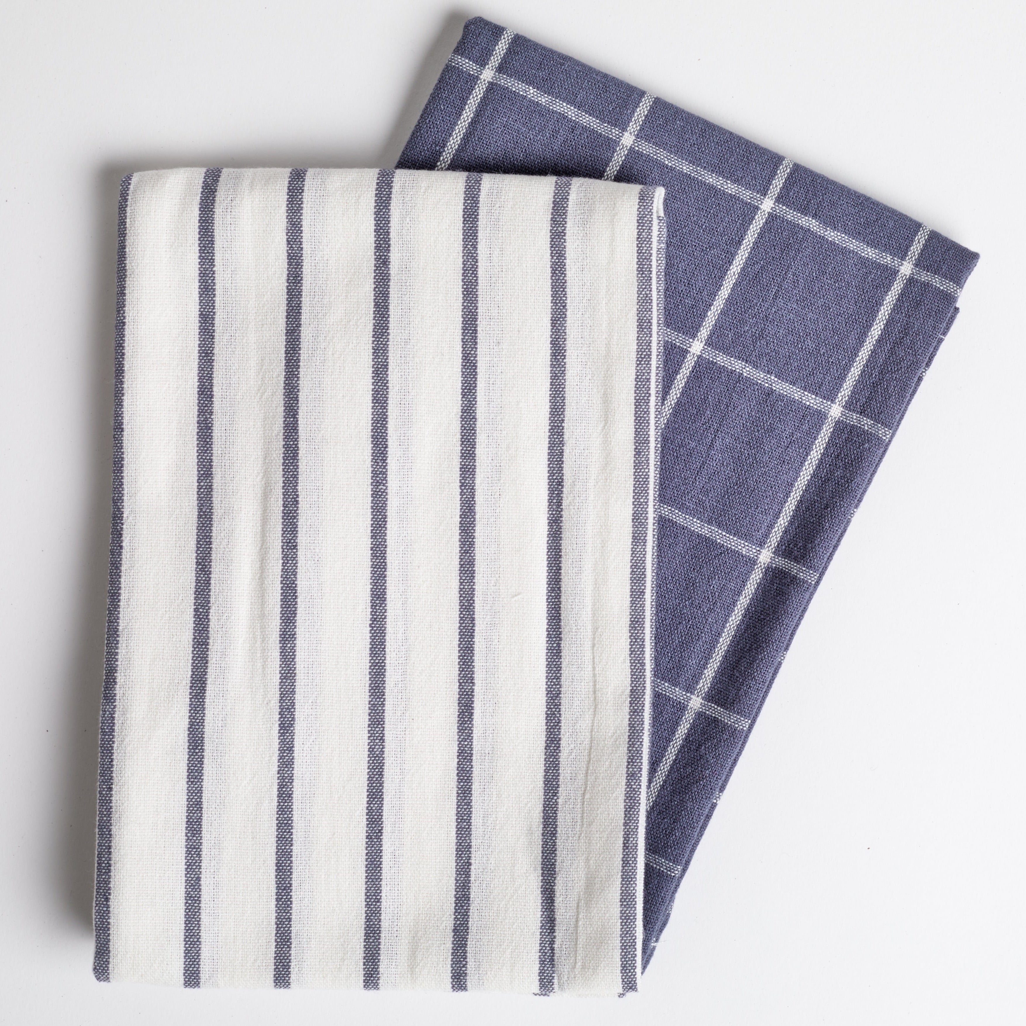 A blue and white plaid dish towel paired with a white and blue striped dish towel against a white background